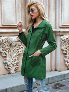 Vista laterale di un impermeabile verde con cappuccio e coulisse in vita e zip