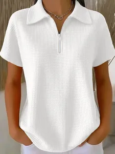 Détail d'un polo blanc en maille gaufrée avec col zippé et coupe décontractée élégante