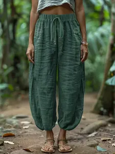 Detail of loose green linen-style harem pants with drawstring elastic waist for women
