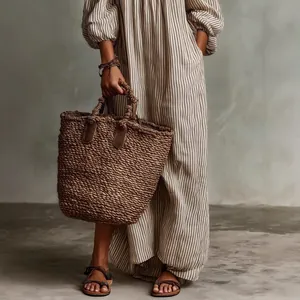 Detailed view of striped resort style long sleeve maxi dress with woven basket bag