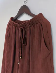 Rust red lantern pants detail showing elastic drawstring waist and textured fabric.