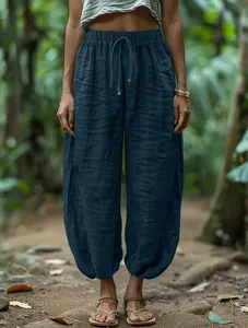 Close-up of loose dark blue lantern pants featuring an elastic drawstring waist design