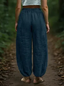 Back view of casual loose navy lantern pants with elastic waist in forest setting