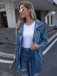 Stylish blue hooded zip-up raincoat for women, modeled in a trendy urban outdoor setting.
