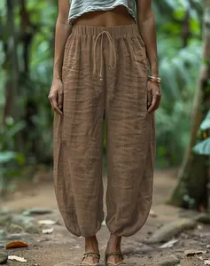 Relaxed brown linen-textured lantern pants with elastic drawstring waist shown on model