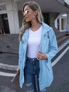 Close-up of a fashionable light blue hooded raincoat with zipper and snap buttons.