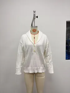 Dettaglio di un maglione da donna in maglia bianca con collo a polo e bottoni decorativi