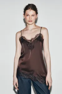 Detailed view of brown silk camisole with black lace trim and asymmetric hem design