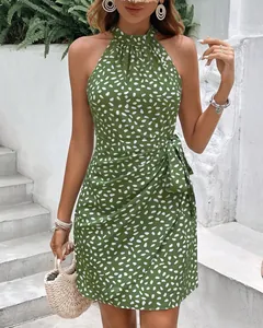 Dettaglio di un abito verde allacciato al collo con pois bianchi e fiocco in vita