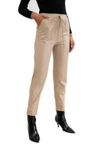 Détail du pantalon en similicuir beige avec taille à cordon et couture genou