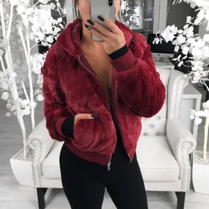 Gros plan montrant la texture pelucheuse d'une veste à capuche en fausse fourrure rouge vin