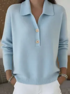 Close-up detail of a light blue knitted sweater featuring a neat collar and two buttons.