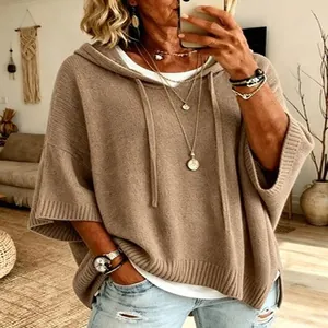 Close-up detail of a women's casual khaki knitted hooded poncho with loose fit.