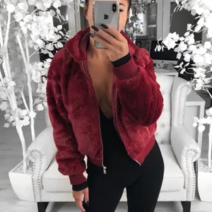 Vue détaillée d'une veste à capuche en fausse fourrure bordeaux avec poignets côtelés