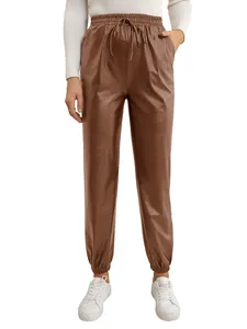 Close-up detail of women's brown PU leather jogger pants with drawstring waist design
