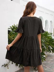 Back view of a black tiered casual dress with ruffle sleeves and textured fabric