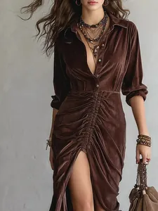 Close-up detail of luxurious brown velvet shirt dress with ruched waist and high slit
