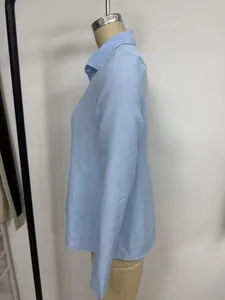 Detail side view of a light blue loose collared long-sleeved shirt on a mannequin