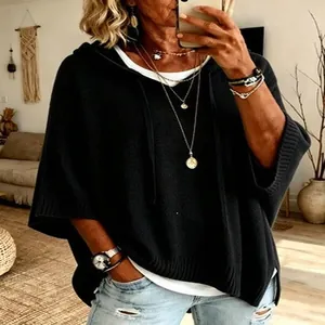 Detailed view of a loose black hooded knit poncho sweater with drawstrings