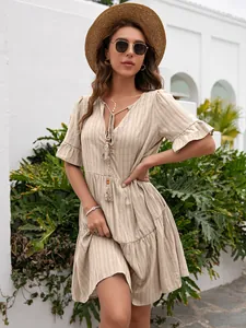 Detail of beige striped loose casual V-neck dress with ruffle sleeves and tassels