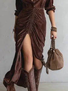 Detailed view of a brown velvet ruched shirt dress with front slit and long sleeves