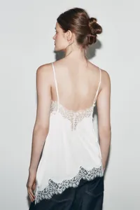Rear view of white silk camisole with delicate asymmetric lace trim and thin straps