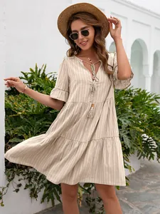 Detailed view of the casual V-neck dress with tassel tie and tiered skirt design