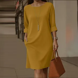 Gros plan sur une élégante robe jaune moutarde à col rond avec des poches latérales