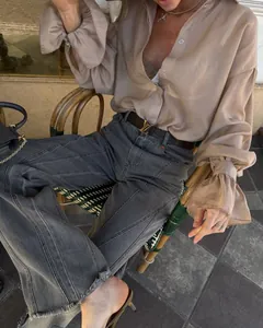 Vista detallada de una camisa beige holgada para mujer con elegantes mangas farol y cuello