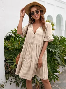 Close-up of a beige tiered V-neck dress with ruffled sleeves and elegant button details