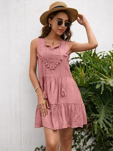 Vista detallada de un vestido de verano rosa sin mangas con elegantes adornos de encaje.