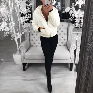 Selfie miroir d'une femme portant une veste à capuche en fausse fourrure blanche