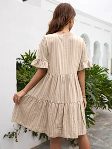 Detailed back view of a beige tiered ruffle dress with vertical striped fabric texture
