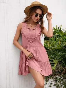 Vestido bohemio rosa sin mangas con delicados detalles de encaje y elegantes borlas.