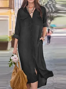 Full-length view of a black long-sleeved denim shirt dress with pockets and a classic collar.