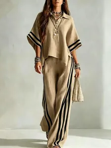 Full-length view of a beige linen two-piece set with black stripe details.