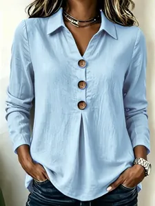 Loose light blue long sleeve top with V-neck, collar, and large brown button detail