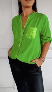 Detailed view of bright green shirt with sequin pocket and button-down front style
