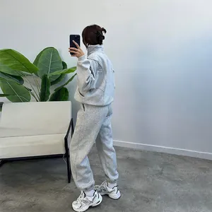 Side view detail of a grey fleece tracksuit with loose zip hoodie and sweatpants.