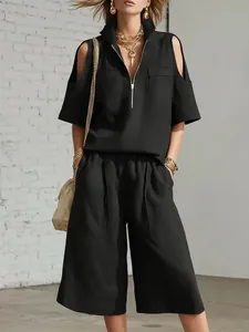 Vista detallada del conjunto negro de dos piezas con top de hombros descubiertos y shorts.