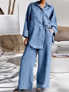 Mujer con conjunto de camisa azul holgada y pantalones de pierna ancha en exterior soleado
