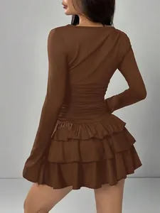 Back view of a brown long sleeve dress with ruffled layers and a slim fit waist.