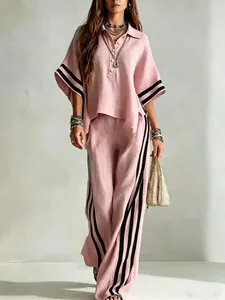 Stylish pink two-piece outfit featuring a short-sleeve shirt and wide-leg striped pants