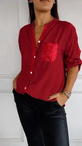 Close-up detail of women's red casual long sleeve shirt with sequins pocket and button-down trim