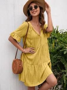 Detail view of yellow V-neck casual dress with ruffled sleeves and textured fabric