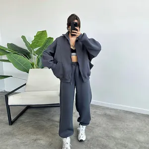 Woman wearing a stylish grey oversized zip-up hoodie and matching sweatpants loungewear set