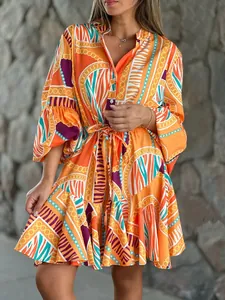 Abito a balze arancione con stampe geometriche e maniche a campana