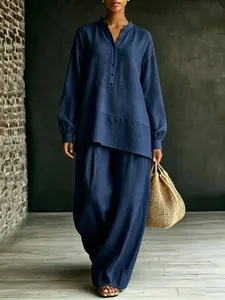 Gedetailleerd overzicht van een elegante donkerblauwe damesset met tuniek en wijde broek