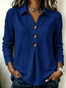 Detailed view of royal blue shirt collar with three large brown wooden-style buttons