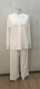 Dettaglio di un set da casa in maglia waffle bianca con top a bottoni e pantaloni.